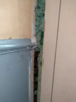 Large gap between front door frame and wall.