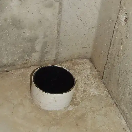 Polyethylene sewer pipe emerging from basement floor, uncapped