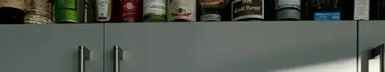 top edge of kitchen cabinets with bottles sitting on it