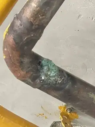 Closeup of oxidation on elbow of copper pipe