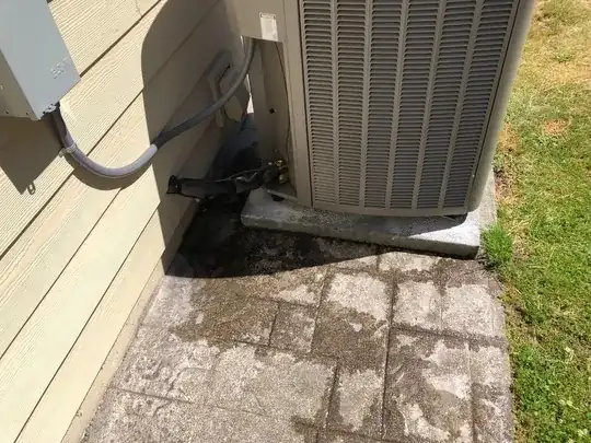 Outdoor heat pump unit with water pooling next to it