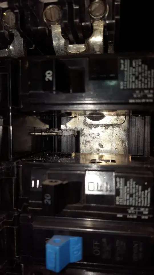 White deposits under breaker on hot bus bar in electrical panel