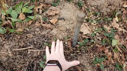 woman's hand next to a second capped off metal pipe