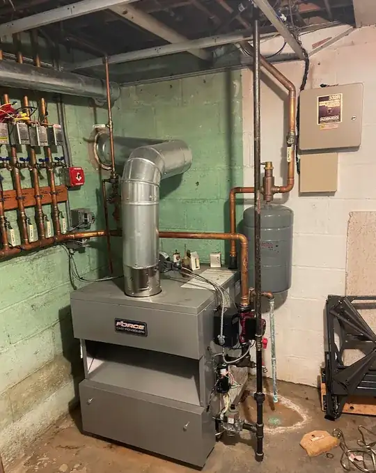 Full boiler system with black return pipe on right going to ceiling