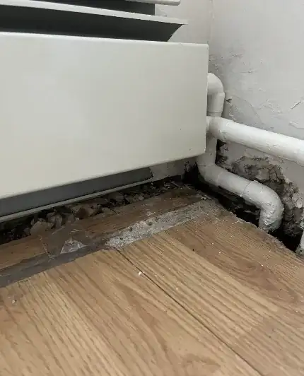 Unfinished floor and wall near heater