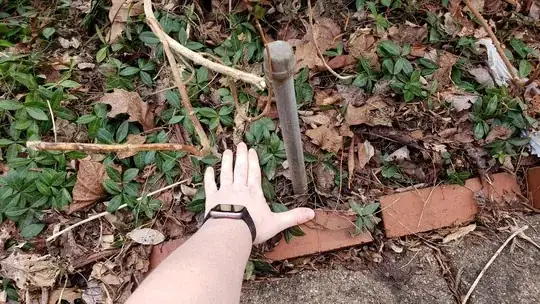 woman's hand next to a capped off metal pipe
