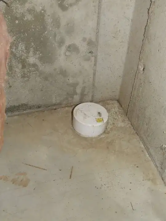 Polyethylene sewer pipe emerging from basement floor, capped