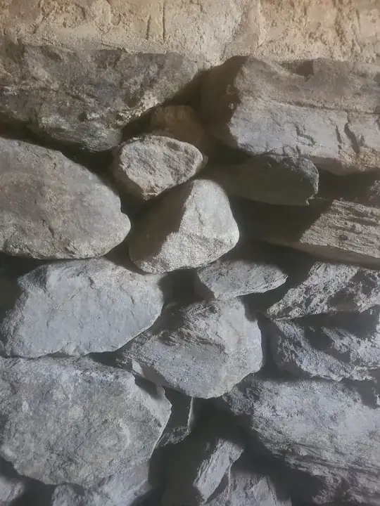 another section where I don't see any mortar, only right at the top where the stone meets the brick. there isn't really any dirt in this section as an addition was put on and the opposite side is now inside, no ground behind it.