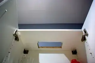 Hole cut in cabinet above the vent