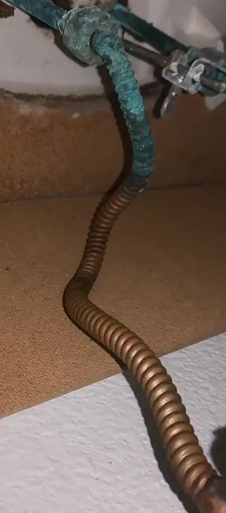 Corrugated copper pipe with fitting at the upper end