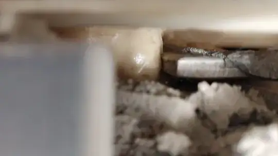 side view inside showing PU foam blob and a tile or two pancaked and mortar or cement-like something, some PU foam is visible in the "distance" that's likely glue-ing the factory-PU of the shower tray's underside hmmm...