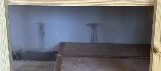 Image under stairs with dark spots dripping/seeping between cinder blocks