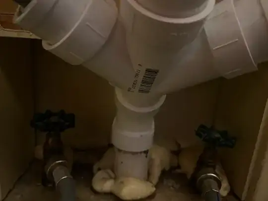 close up of 3-way T connected to metal drain pipe