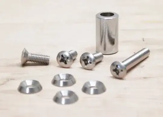 Four small bolts with countersunk washers and an unidentified cylindrical item.