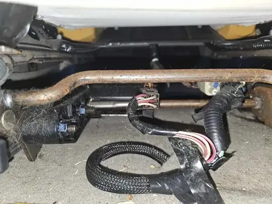 Underneath the driver's seat from the back, looking towards the front of the car