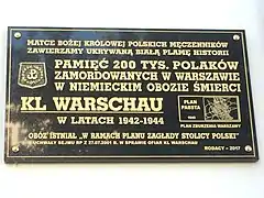 Commemorative plaque placed in 2017, which follows Trzcińska's hypothesis of the camp's history. The plaque reads: "We consecrate the white blot of history that was being hidden [from us] to Our Lady, the Queen of Polish martyrs: In homage to the 200,000 Poles murdered in Warsaw in the German extermination camp KL WARSCHAU in 1942-1944. The camp existed 'in the framework of the annihilation of the Capital of Poland' - from the Sejm resolution dated 27 July 2001 on the victims of KL Warschau. Compatriots - 2017" To the right, a scheme of Warsaw appears with the caption "Pabst Plan - 1940 - Plan of Warsaw's destruction".