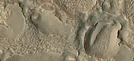 Close view of hollows formed when ice left the ground by sublimation. This was named a HiRISE picture of the day. The ridges were formed when hollows that were next to each other grew in size.