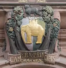 The coat of arms of Coventry over the entrance to the Council House. Coventry's motto Camera Principis translates as "The Prince's Chamber", used because Coventry was regarded as the chamber of Edward, the Black Prince.