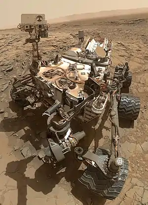 Image 2CuriosityPhotograph credit: NASA / JPL-Caltech / MSSSCuriosity is a car-sized rover designed to explore the crater Gale on Mars as part of NASA's Mars Science Laboratory mission. It was launched from Cape Canaveral in November 2011 and landed on Aeolis Palus inside Gale on August 6, 2012, at 05:17 UTC. Curiosity's landing site, nicknamed Bradbury Landing, was less than 2.4 km (1.5 mi) from the center of the rover's touchdown target after a 560-million km (350-million mi) journey. The rover's goals include an investigation of the Martian climate and geology; assessment of whether the selected field site inside Gale has ever offered environmental conditions favorable for microbial life, including investigation of the role of water; as well as planetary habitability studies in preparation for human exploration.This picture is a self-portrait of Curiosity on Mars at the "Big Sky" drilling site, where it collected a rock sample at the foothills of Aeolis Mons (Mount Sharp) in October 2015. The photograph combines dozens of images taken by the Mars Hand Lens Imager (MAHLI) camera at the end of the rover's robotic arm; the arm itself is not included, although its shadow is visible on the ground. Wrist motions and turret rotations on the arm allowed MAHLI to acquire the mosaic's component images.More selected pictures