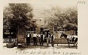 George Hennessey (center), manager of the Bucket of Blood Saloon, outside the saloon in 1908