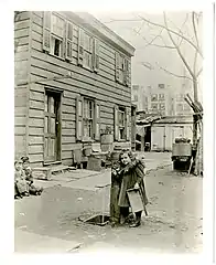 Unidentified girl at the water pump at the rear of 65 E. 87th Street, north side between Madison and Park, New York City, April 21, 1898