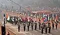 Indian Army bands marching behind an ASEAN flag bearer contingent through the Rajpath