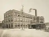 A brick factory with smoke coming out of the chimney