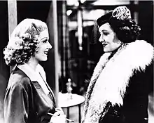 Gray-scale film still of Harlow and Loy facing each other