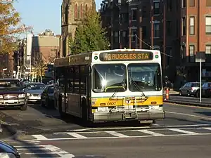 A white and yellow transit bus on an urban street