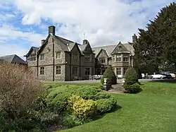 a large stone building with shrubs and grass in the foreground