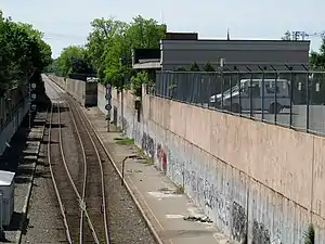 Asphalt platforms in a trench, with a one-story building in the background