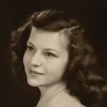 a tight headshot sepiatone image of a young woman with long flowing hair in 3/4 profile