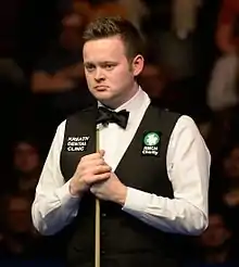 Shaun Murphy stood up, holding his cue
