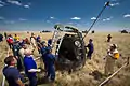 Russian Search and Rescue crews attach ladders and a slide for access to the capsule.