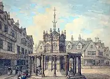 Squat octagonal structure, surrounded by tall thin buildings. A tall narrow structure, also octagonal, rises from it, topped by a cross.