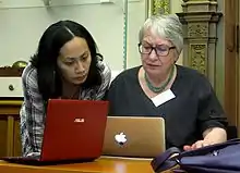 Two people working together intently on two laptops