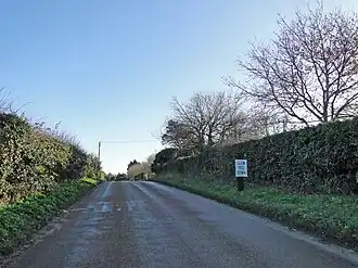 A country road with the sign "Slow You Down"