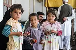 Three children hold small toy cars they were given