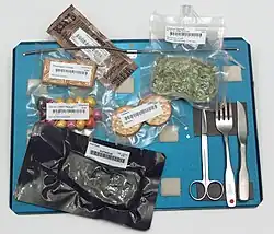 Space food: Cheddar spread, spinach, cookies, peanuts, crackers, steak, and utensils