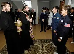 Astronauts receiving blessing from a Russian Orthodox priest