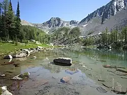 A very clear lake with mountains in the background